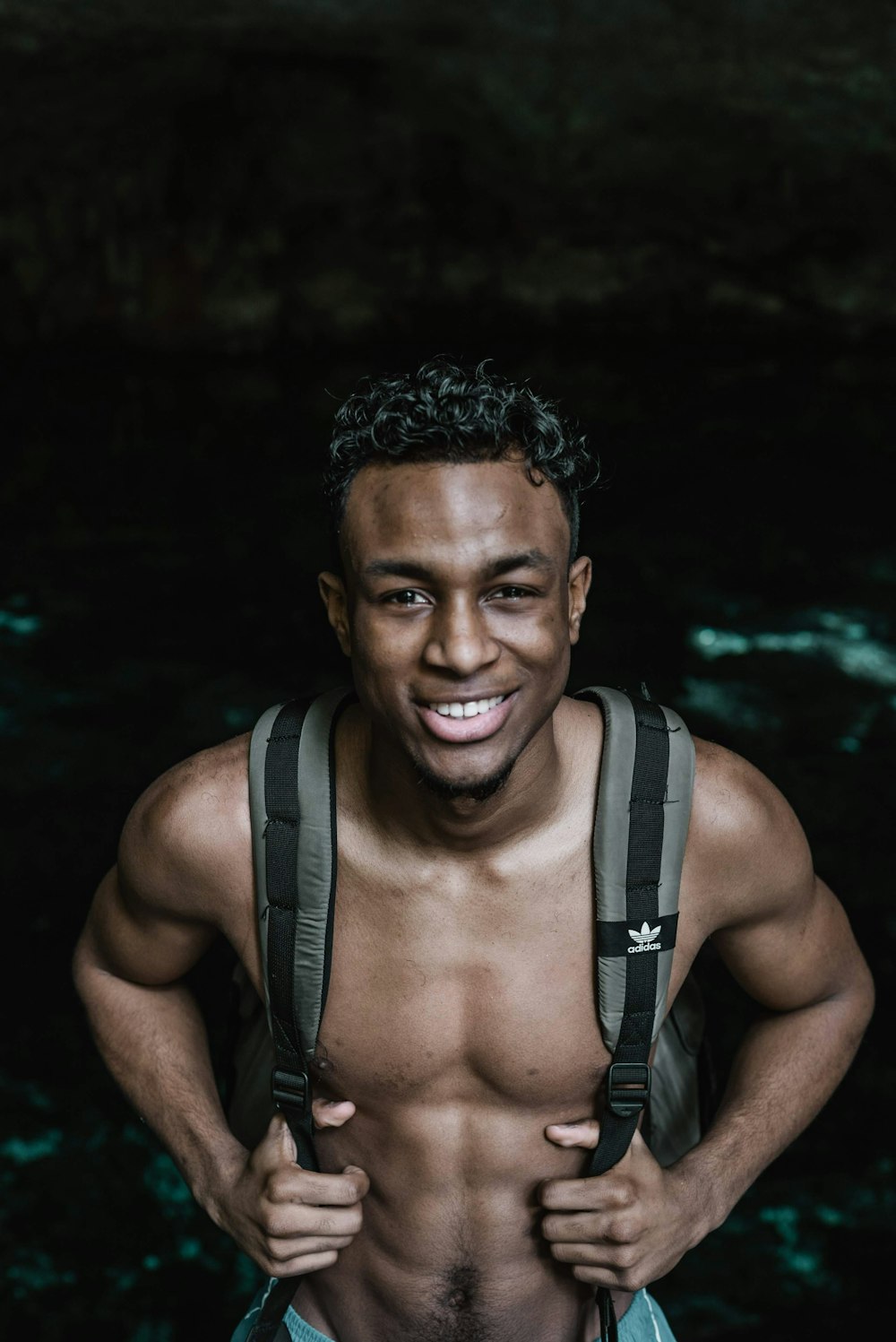 topless man wearing gray and black adidas backpack