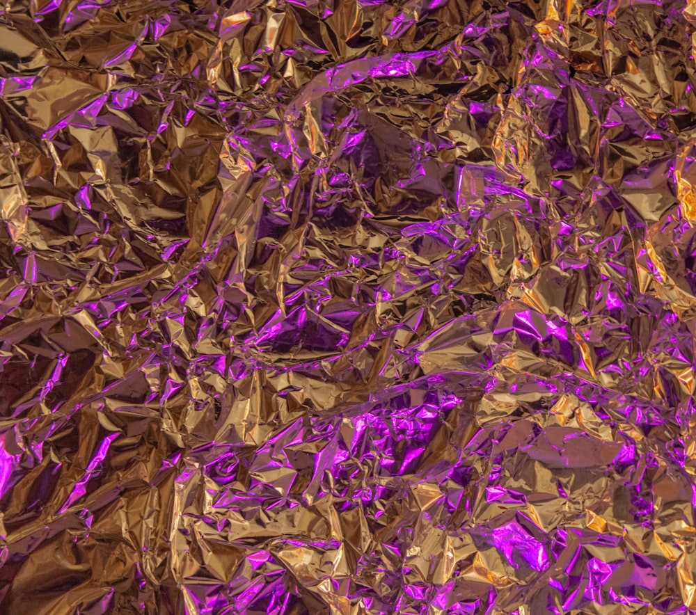 a close up of a purple and gold background