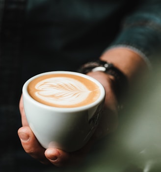 person holding cup of cappuccino