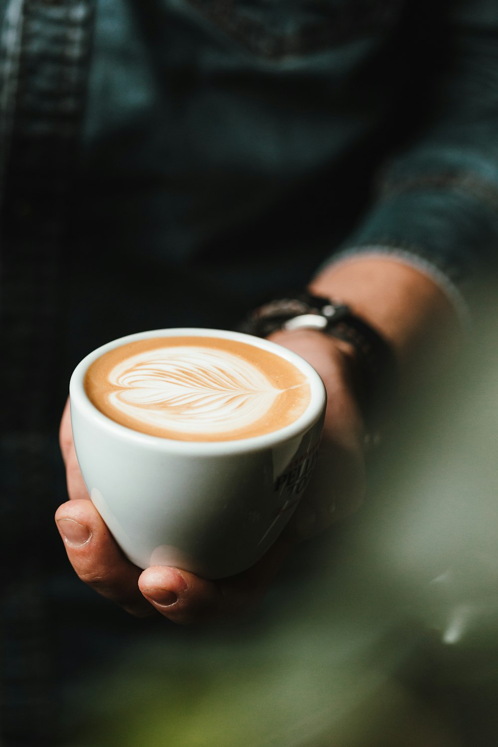 Person mit Tasse Cappuccino