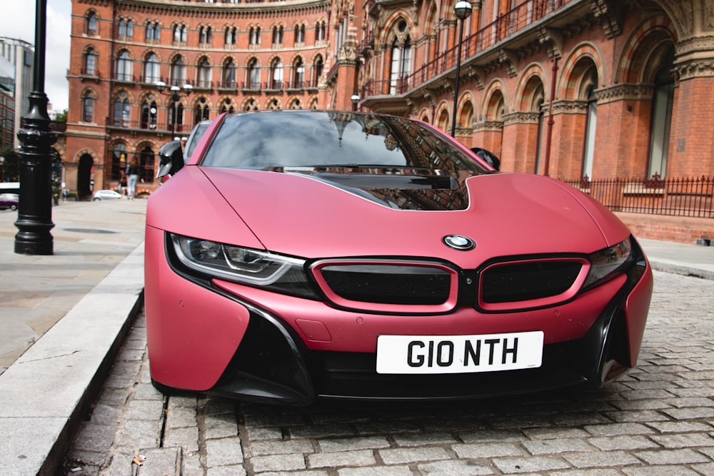 red sports car parked near brown concrete building