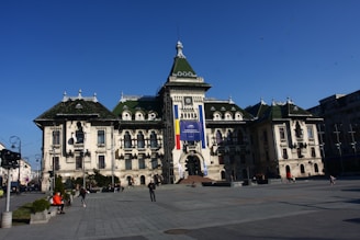 A panoramic view of the Palace of Culture in Iași under a bright sky.