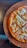Close-up of a freshly baked pizza with melted cheese and vibrant toppings on a wooden table.