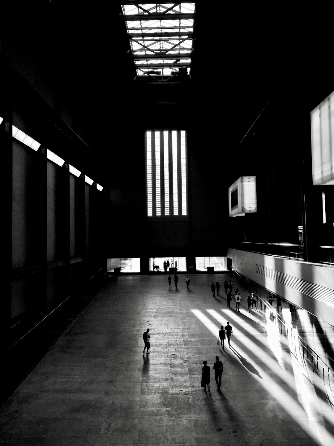 greyscale photo of people walking inside building