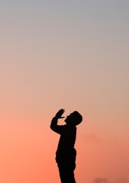 silhouette of man praying after work