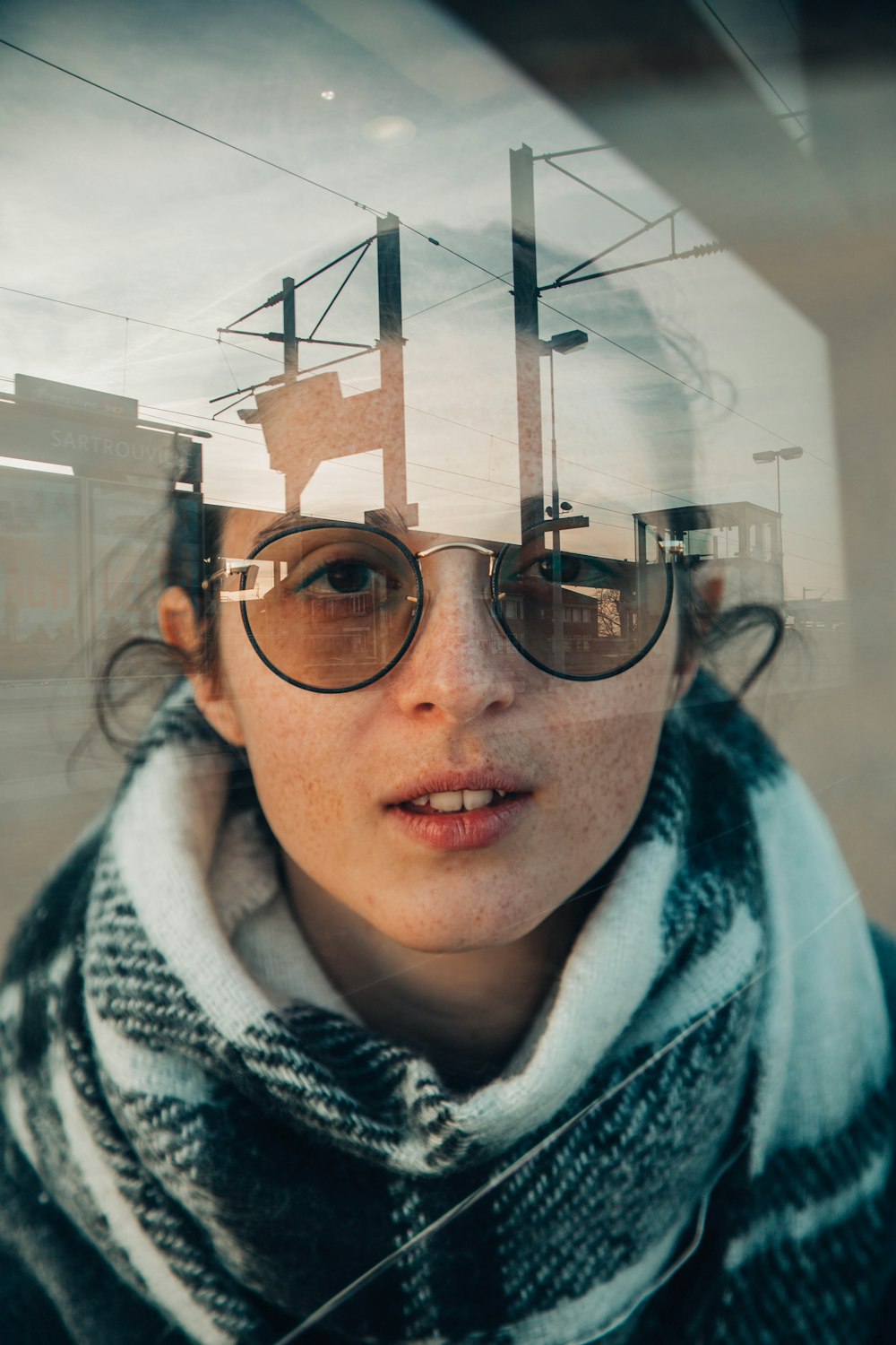 woman wearing sunglasses inside glass panele