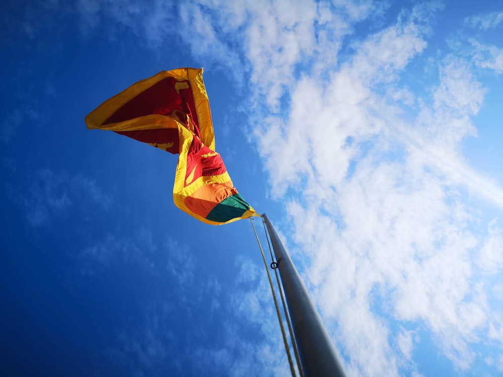 yellow, red, and green flag on pole under daylight