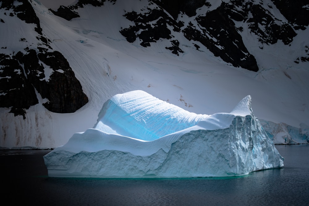 mountain covered with ice near body of water