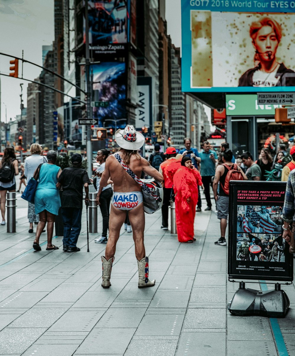 a man in a cowboy hat is walking down the street