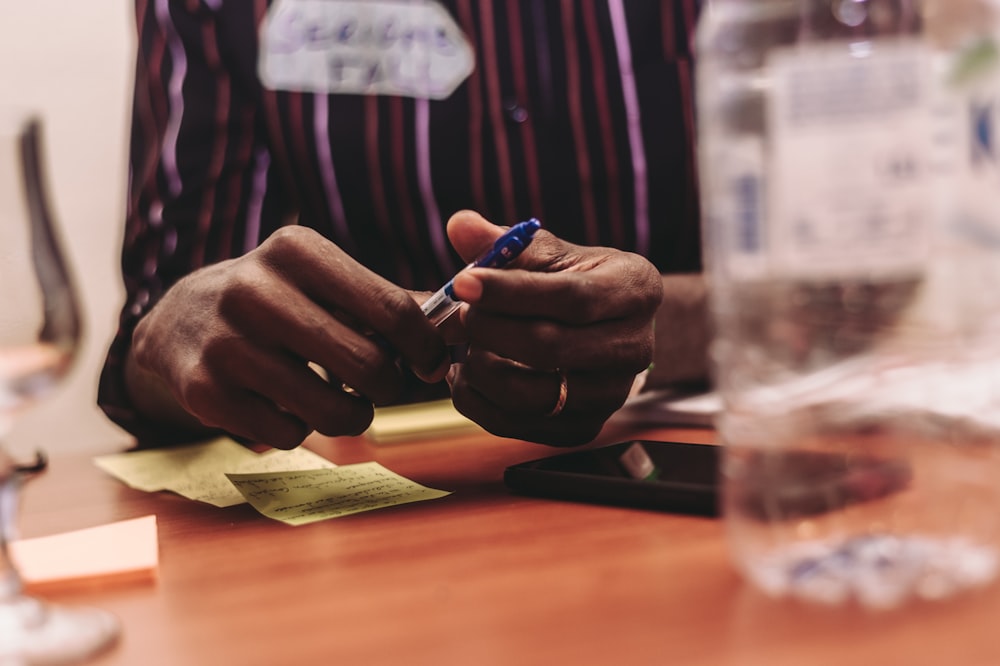 person holding blue pen