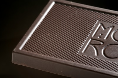 Close-up of artisan hands carefully crafting chocolate bars with natural ingredients.