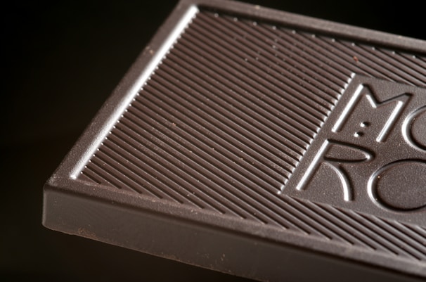 Close-up image of hand-crafted chocolate bars with visible cacao nibs.