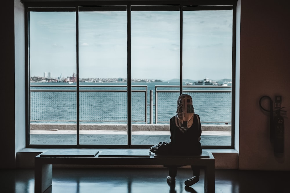 Person, die auf einer Bank sitzt und das Meer beobachtet