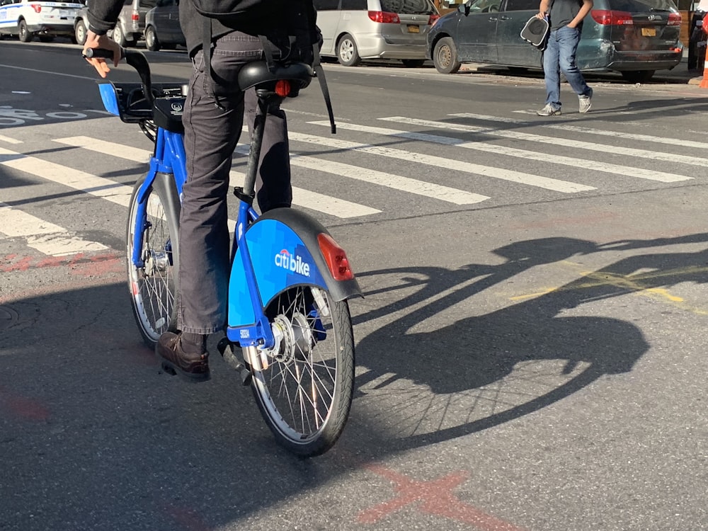man riding blue bicycle