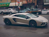 A shiny white sports car with a flawless wax finish parked on a city street.