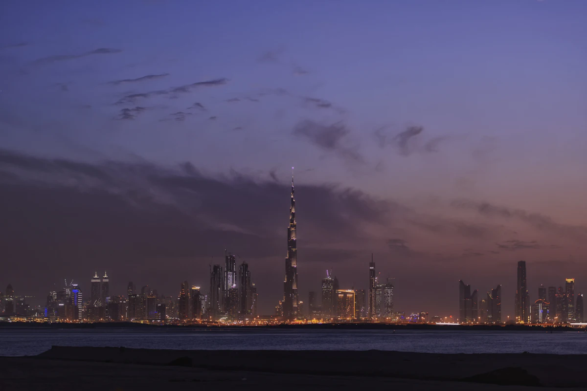 Dubai skyline lit at night, seen across dark water