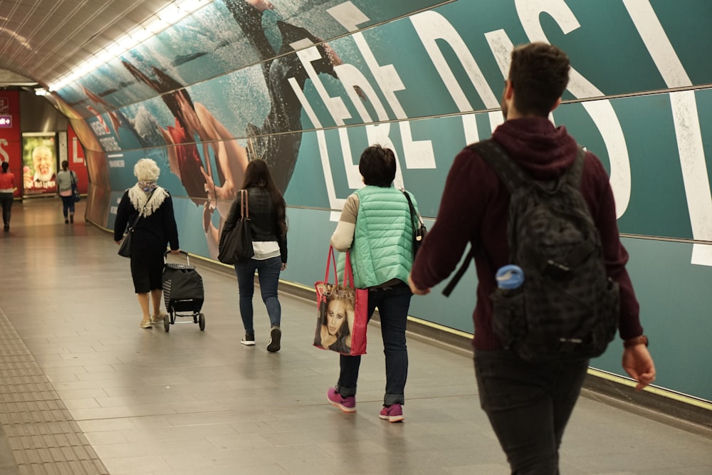 four people walking on hallway