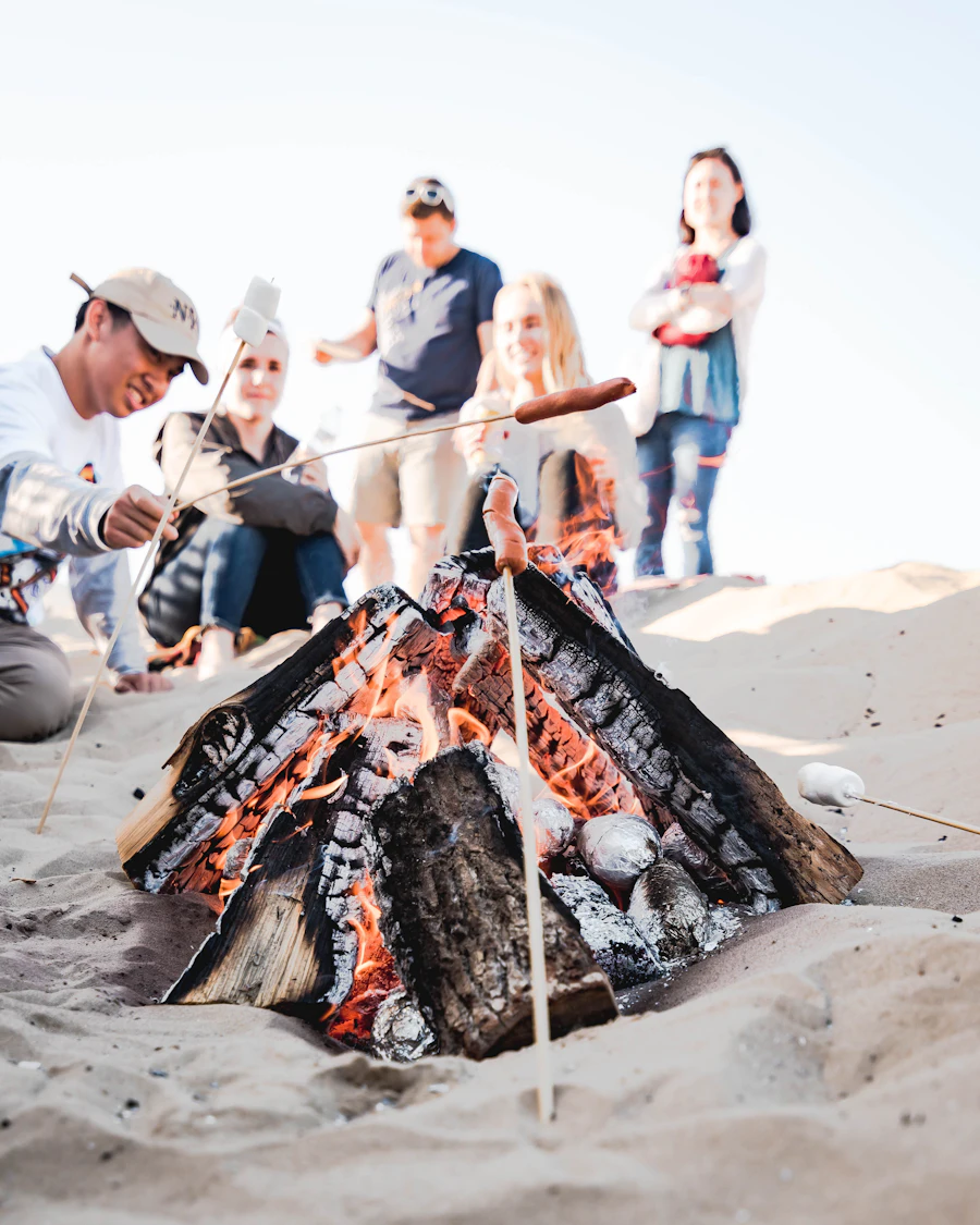 A group sharing a barbecue meal together outdoors at camp