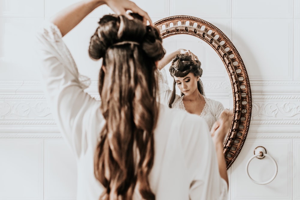 woman wearing white dress standing in front of mirror