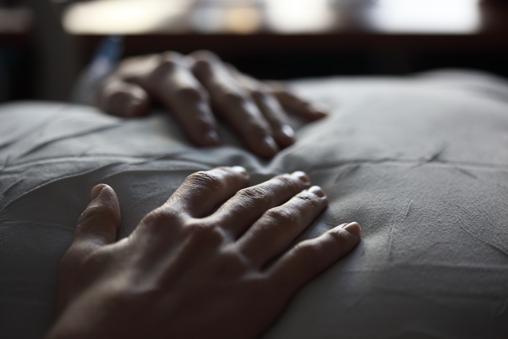 person's hand on white textile