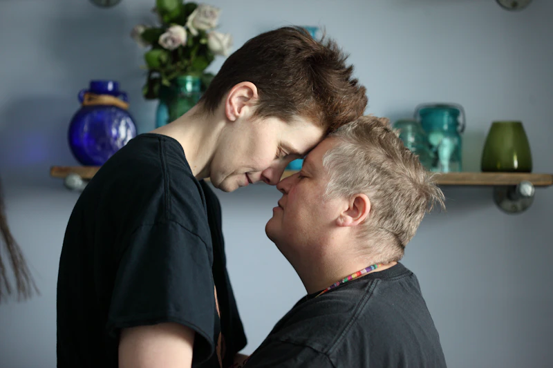Two people resting their foreheads together in a tender, quiet moment