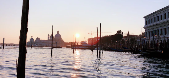 A tranquil canal in Dorsoduro bathed in warm, golden afternoon light with historic buildings softly reflected in the water.