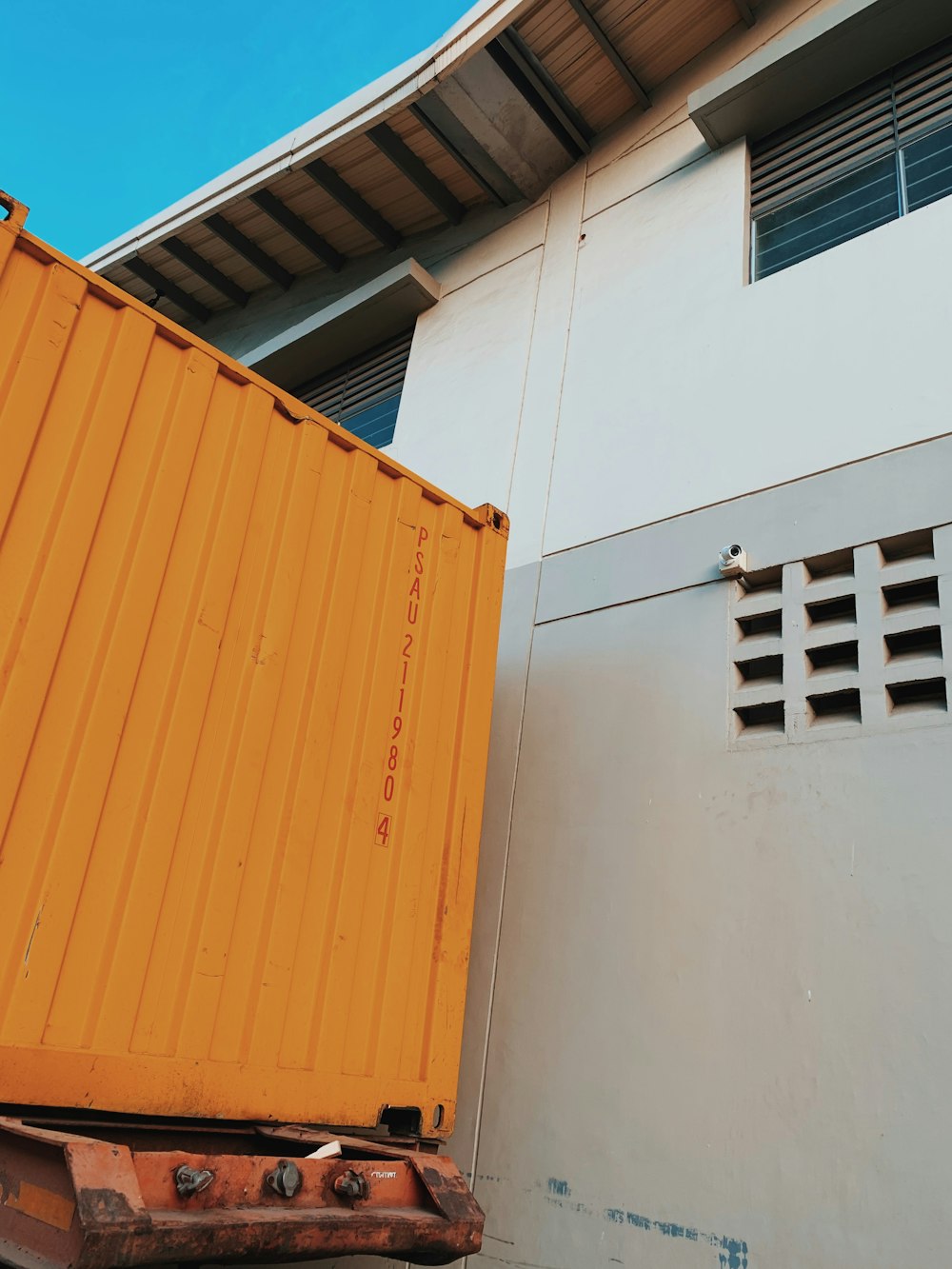 a yellow container sitting on the side of a building