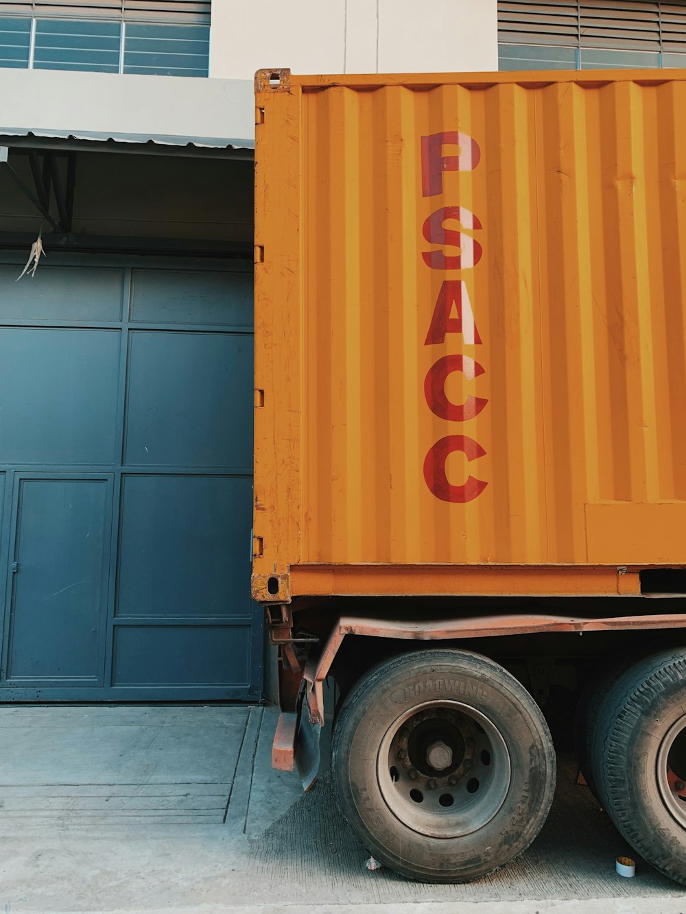 orange truck near white concrete house