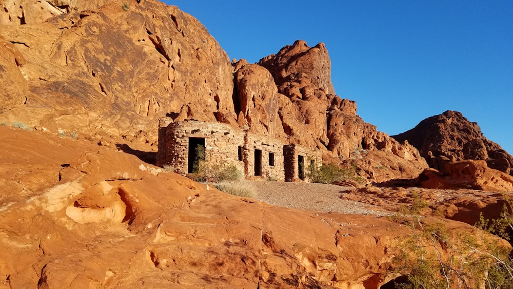 brown brick house near mountain under blue esky