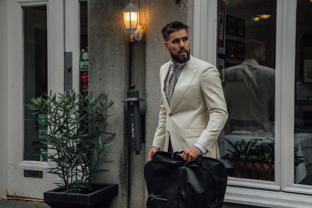 man carrying black garment bag