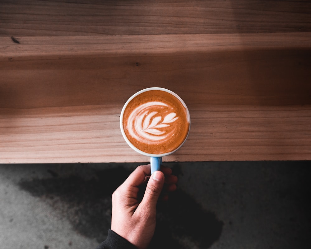 person holding cappuccino latte