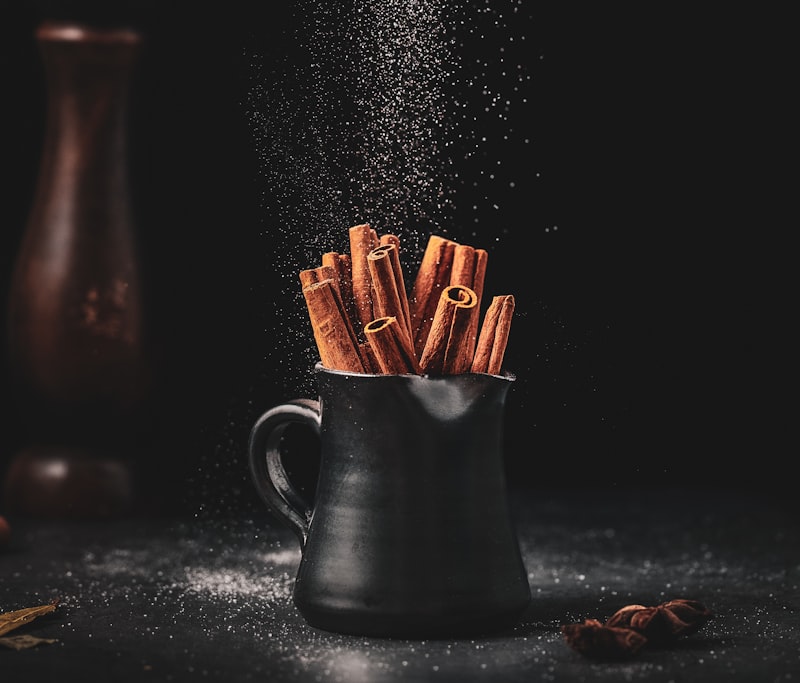 Cinnamon sticks and powder on a wooden surface