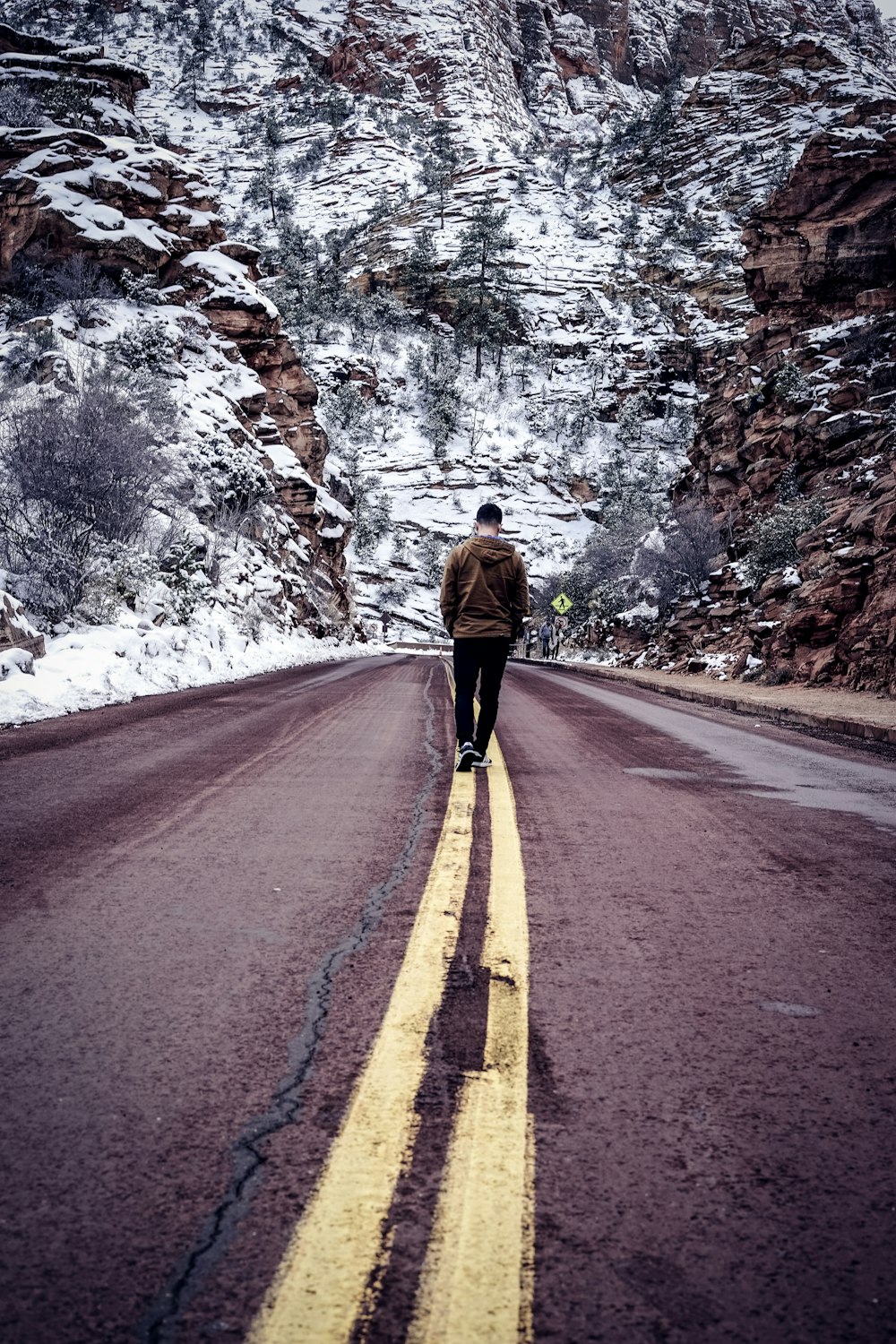 man walking on road during daytime