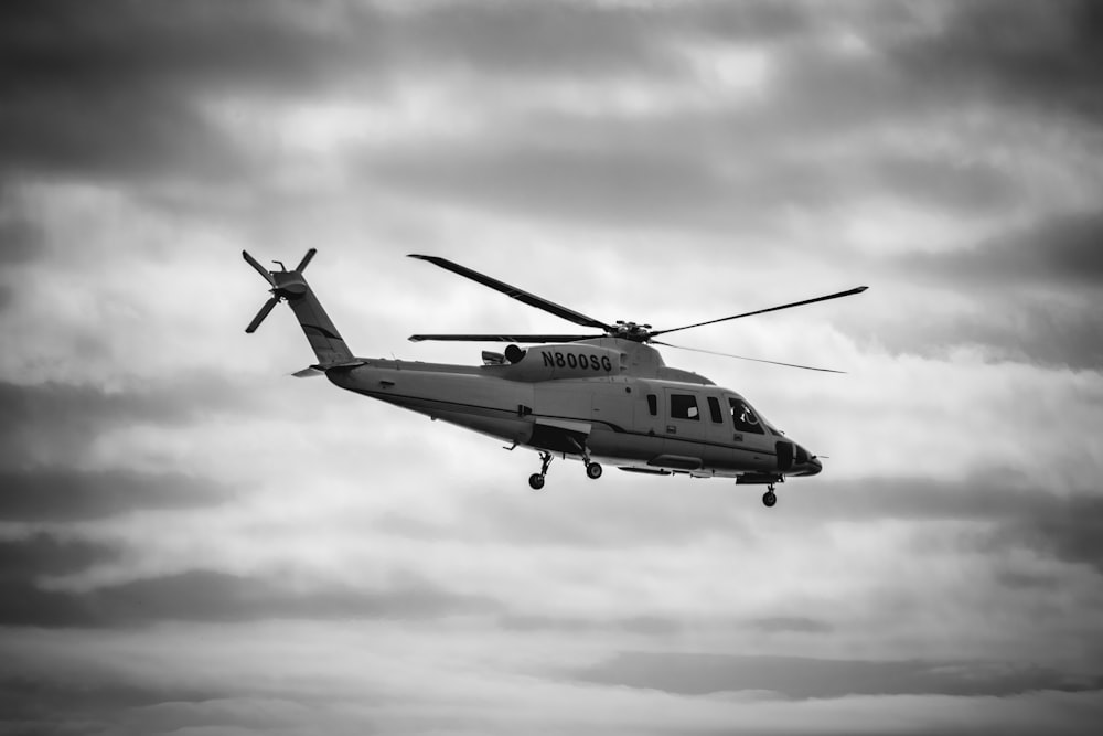 gray helicopter on flight grayscale photo