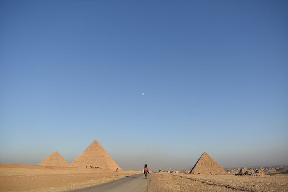 person walking near pyramids during daytime