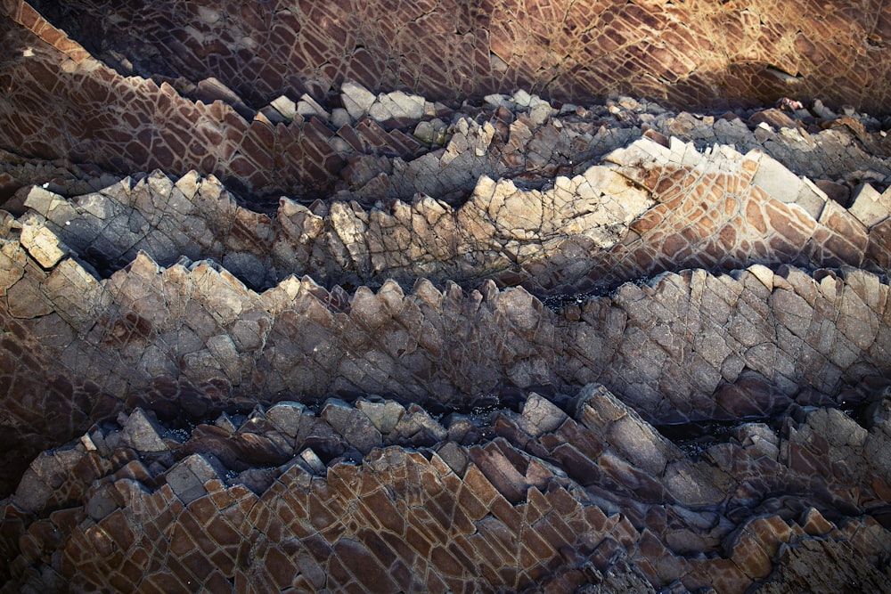 an aerial view of a rocky area with a mountain range in the background
