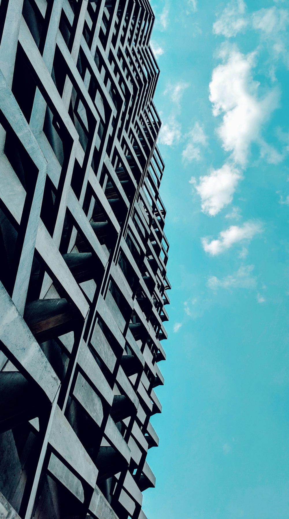 Edificio gris de varios pisos bajo el cielo azul
