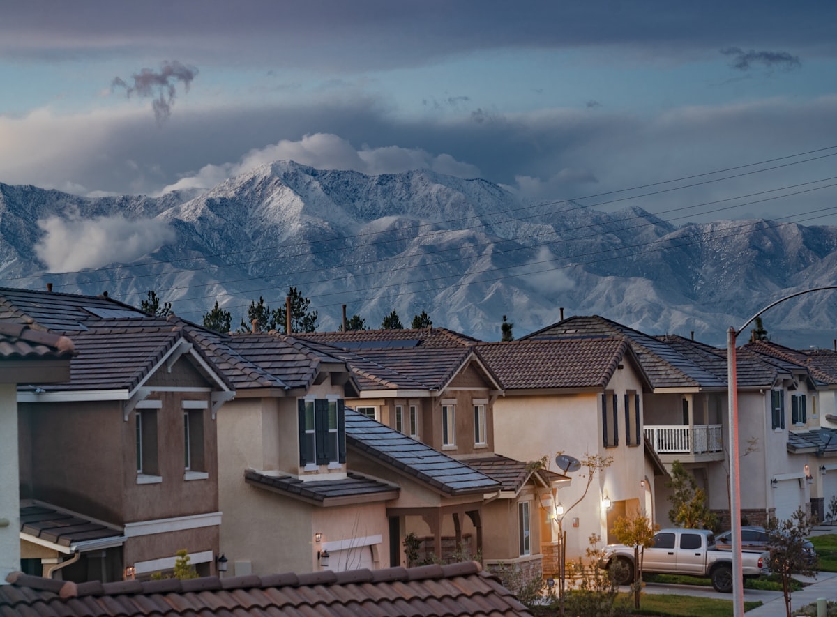 Row of residential houses in a suburban neighborhood with mountains in the background