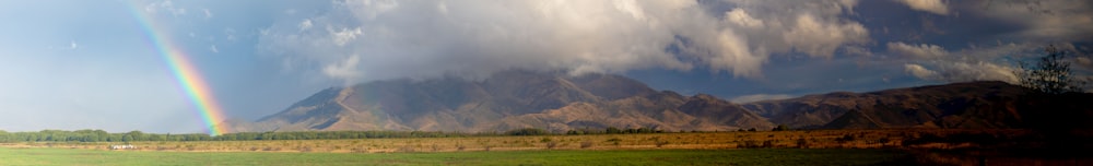 a rainbow in the sky over a mountain range