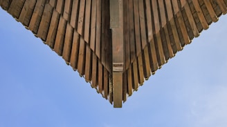 Wide view of a wooden roof structure being carefully restored.