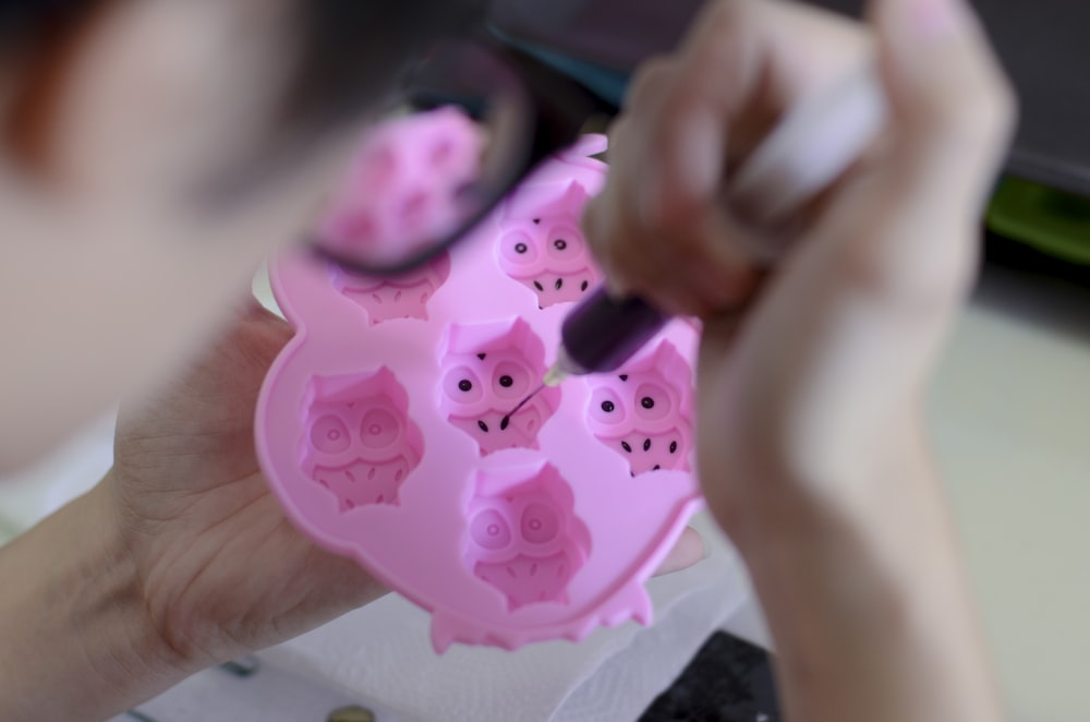 person about to stitch plastic toy using syringe