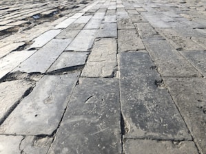 Before and after photos showing a leveled patio slab restored to smooth, even condition.