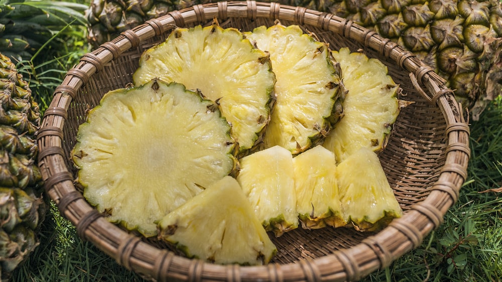 sliced pineapples served on brown basket