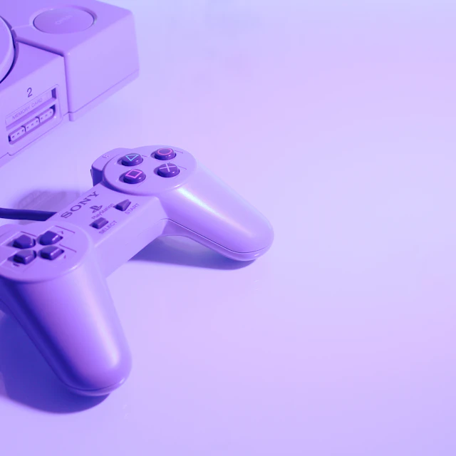 Gray original Sony PlayStation console with its corded controller