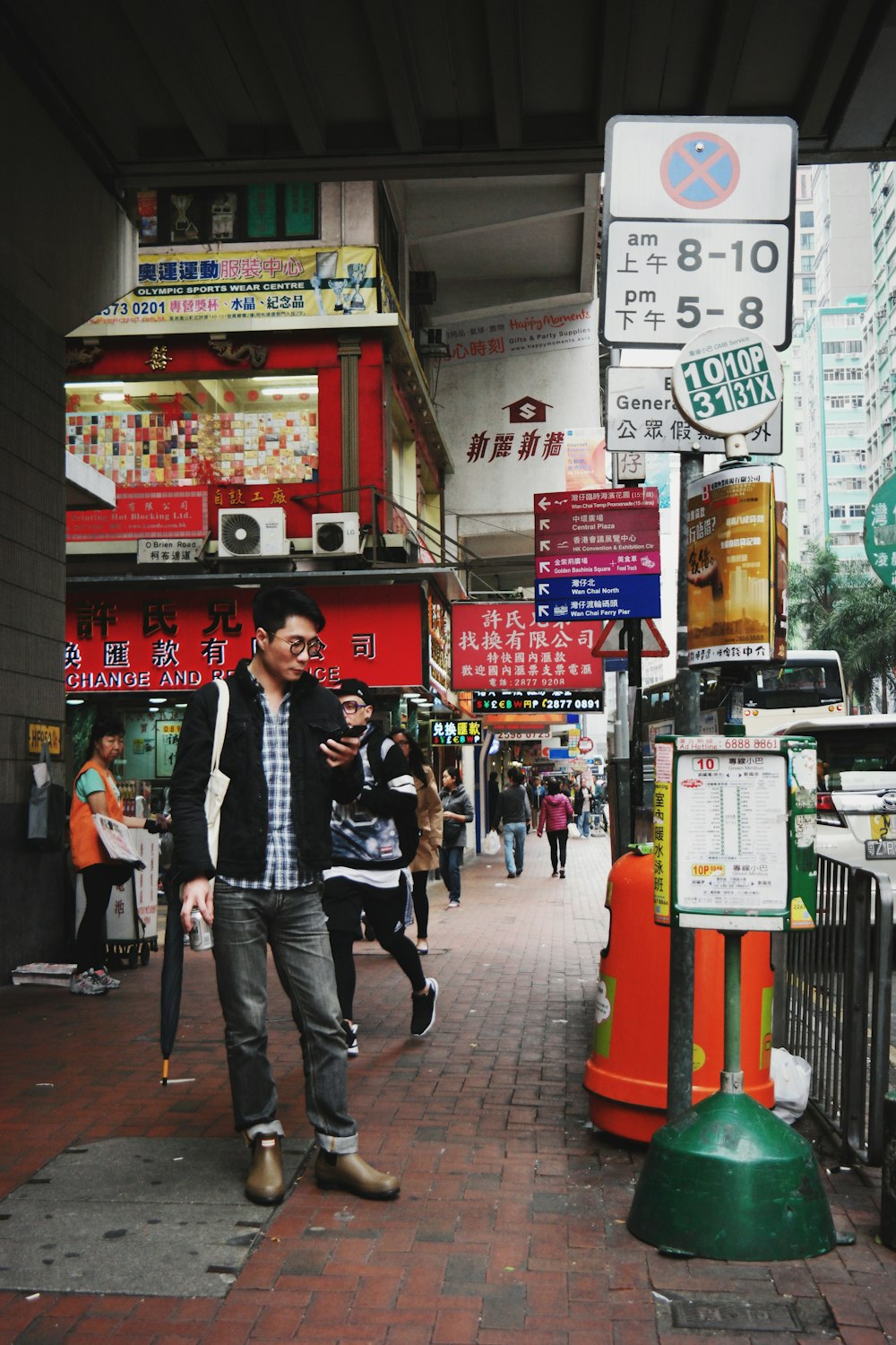 people walking on sidewalk surrounded by buildings during daytime