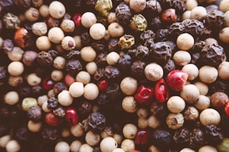 Close-up of black peppercorns next to bright turmeric powder highlighting their synergy.
