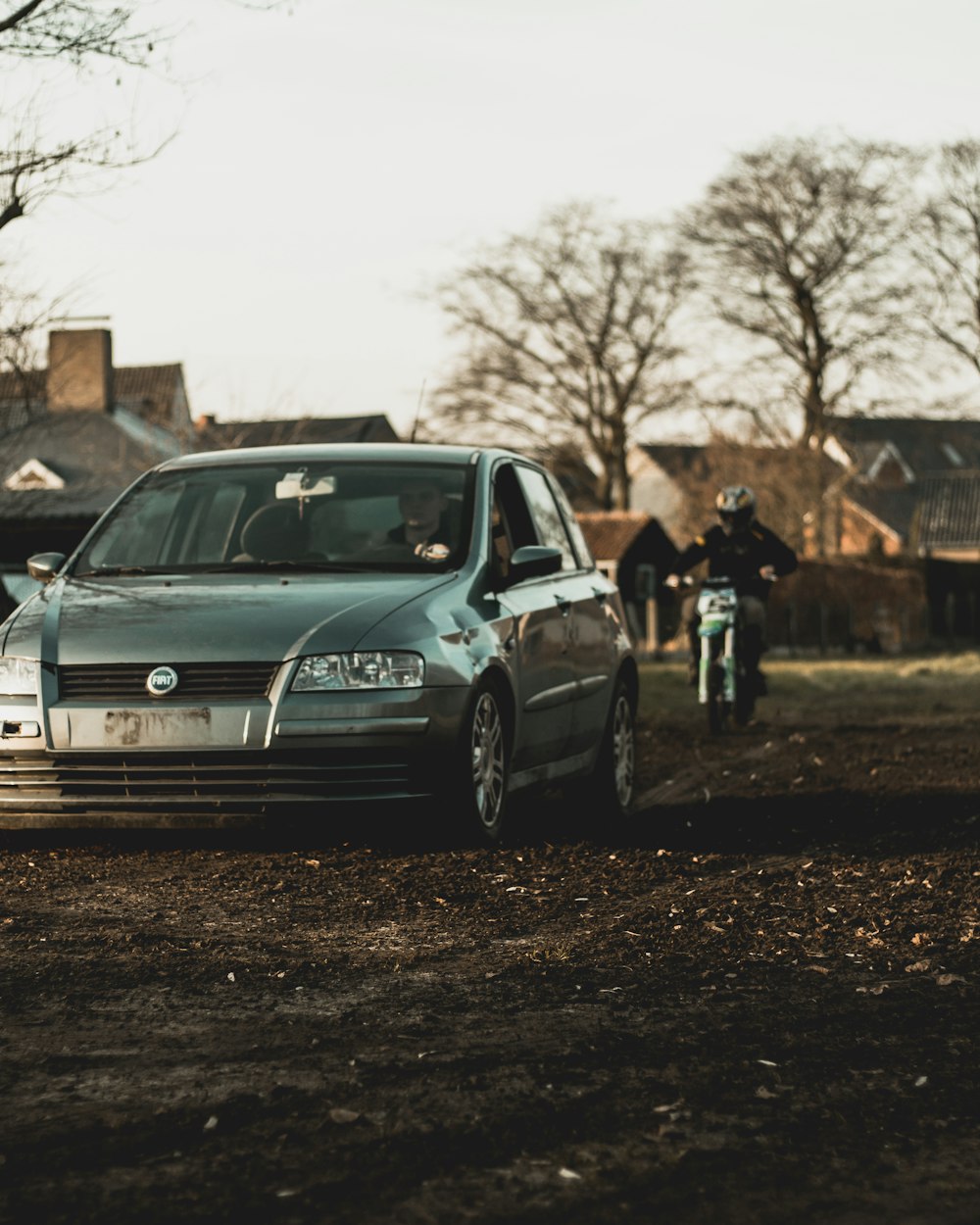 gray sedan behind gray motorcycle