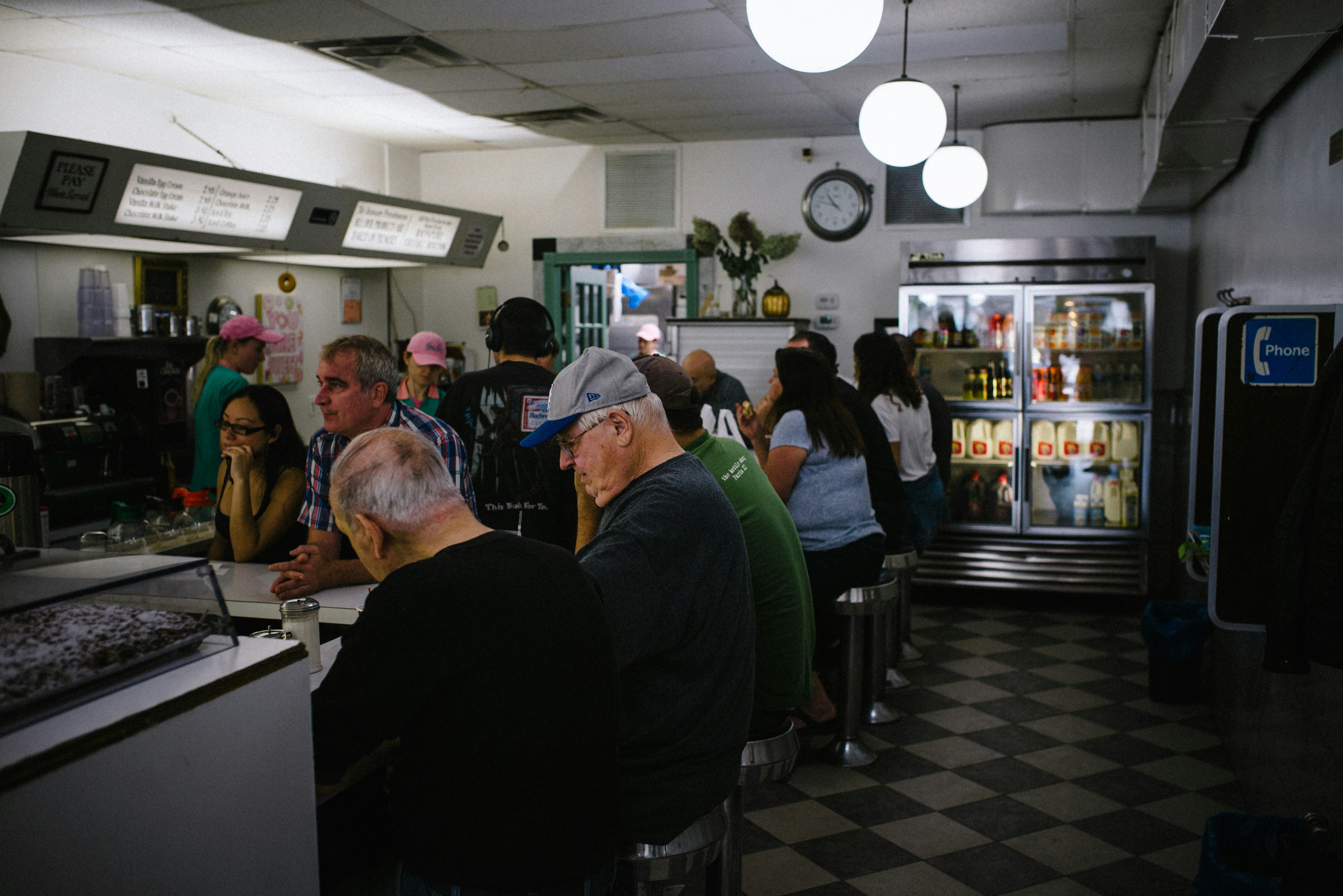 Couple of people eating donuts in a daily. Brooklyn, New York.