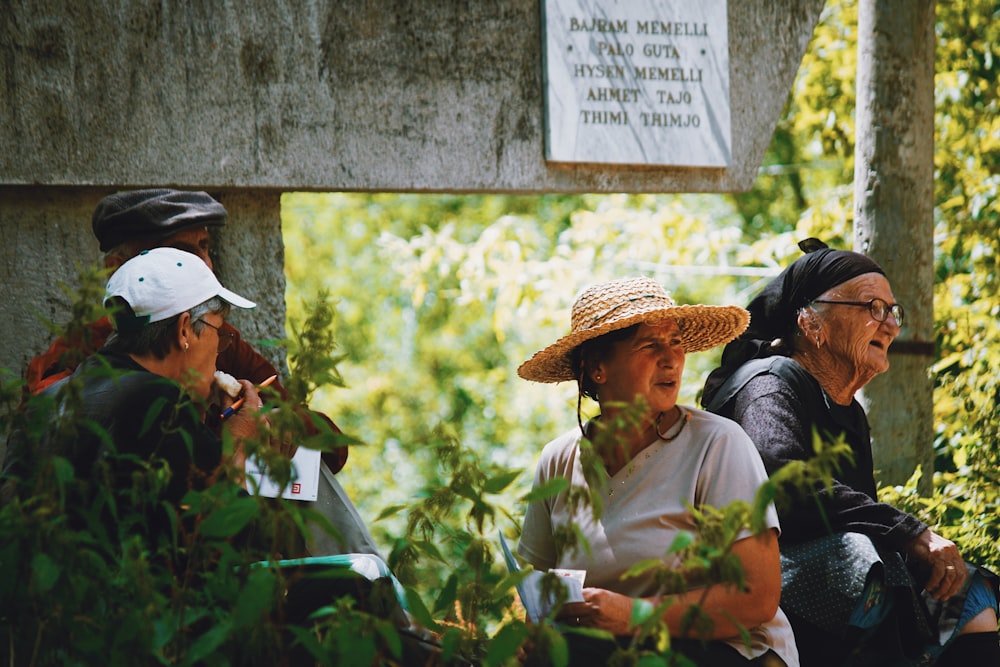 four people standing near trees