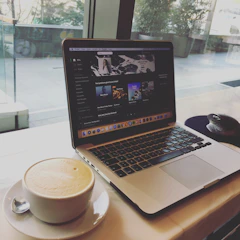 A cozy living room with a laptop open to ondara's live radio player showing a list of FM channels